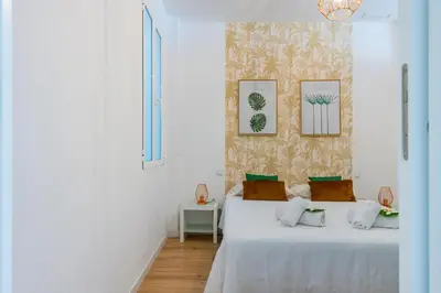 a bedroom with two beds and a wall with pictures at Ayuntamiento Panoramic in Valencia