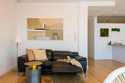 a living room with a black leather couch at Ayuntamiento Panoramic in Valencia