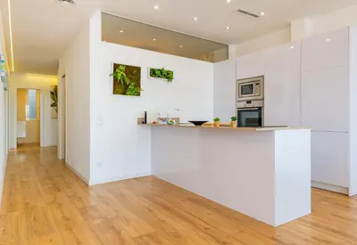 a kitchen with white walls and wooden floors at Ayuntamiento Panoramic in Valencia