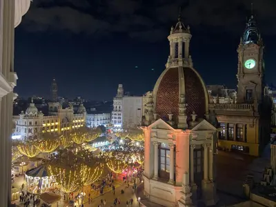a view of a city at night with a clock tower at Ayuntamiento Panoramic in Valencia