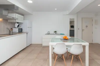 a kitchen with a glass table and two white chairs at BET Apartments - Abastos in Valencia