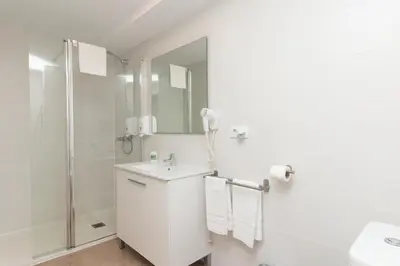 a white bathroom with a shower and a sink at BET Apartments - Abastos in Valencia