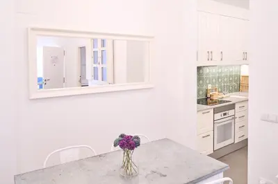 a white kitchen with a vase of flowers on a counter at Splendid houses in Valencia in Valencia