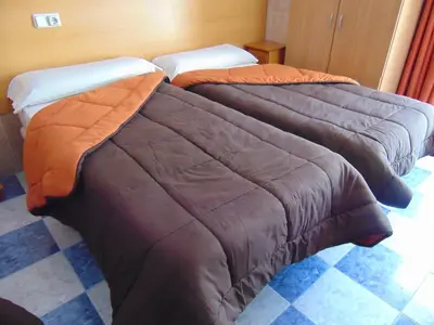 two beds sitting next to each other in a room at Hotel Libertador in Cullera