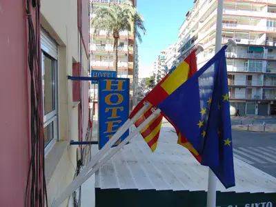 a hotel sign and flags outside of a building at Hotel Libertador in Cullera