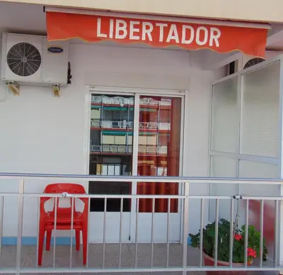a red chair sitting on the front of a library at Hotel Libertador in Cullera