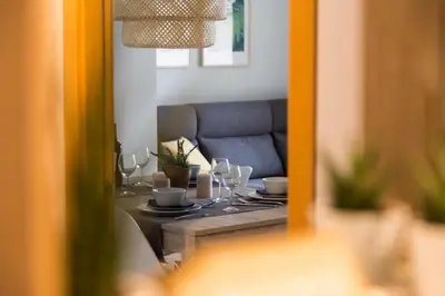 a dining table with wine glasses and a couch at New Aloha Apartment Center with terrace Valencia in Valencia