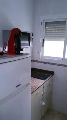 a kitchen with a toaster on top of a refrigerator at 