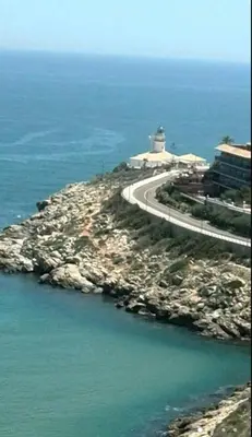 a lighthouse on a rocky island in the ocean at 