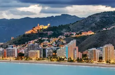 a city with buildings on a hill next to the water at 