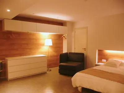 a bedroom with a bed and a chair and a lamp at Apartamento Forn dels Apòstols in Valencia