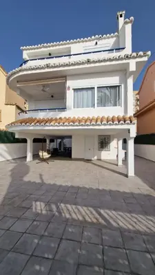 a large white house with a large patio at Beachfront vila in Valencia