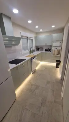 a kitchen with white cabinets and a tile floor at Beachfront vila in Valencia
