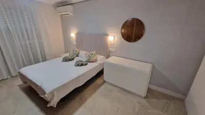 a bedroom with a bed with a dresser and a mirror at Beachfront vila in Valencia