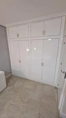 a white kitchen with white cabinets and a tile floor at Beachfront vila in Valencia