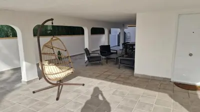 a swing in a room with chairs and a table at Beachfront vila in Valencia