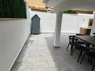 a patio with a blue door and tables and chairs at Beachfront vila in Valencia