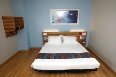 a bed in a room with blue walls at Travelodge Valencia Aeropuerto in Manises