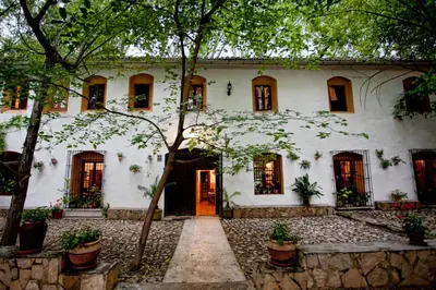 a white house with a tree in front of it at Molino Galán in Alborache
