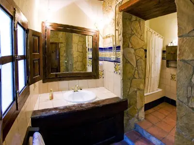 a bathroom with a sink and a stone wall at Molino Galán in Alborache
