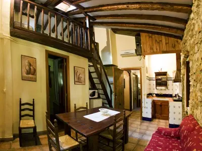 a dining room with a table and a kitchen at Molino Galán in Alborache