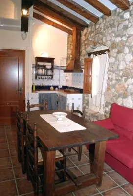 a kitchen with a wooden table and a red couch at Molino Galán in Alborache