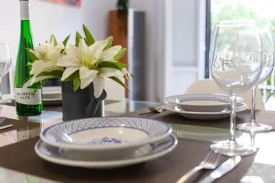 a table with plates and glasses and a bottle of wine at VLC - Cisneros in Valencia