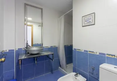 a blue bathroom with a sink and a mirror at Atico Duplex Luminoso in Valencia