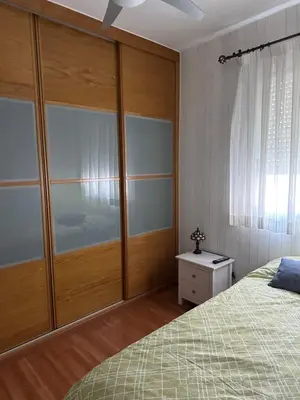 a bedroom with a bed and a large wooden closet at Cristina Apartamento Center in Valencia
