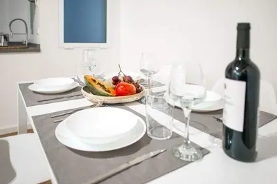 a table with a bottle of wine and a bowl of fruit at Ambrosio Flats Valencia - El Mercat in Valencia
