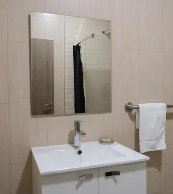 a bathroom with a white sink and a mirror at Hostal Tartessos in Valencia