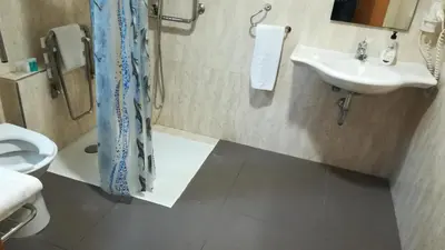 a bathroom with a sink and a toilet at Aparthotel El Faro in Cullera