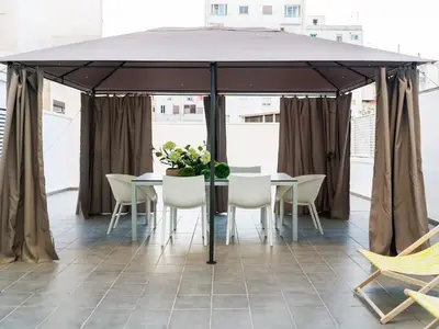 a tent with chairs and a table with flowers on it at Flat El Porto - Valencia in Valencia