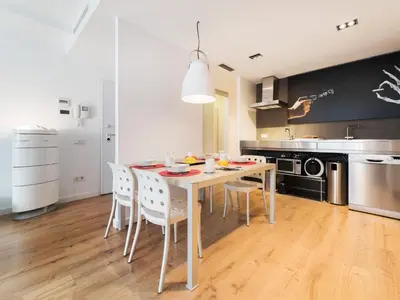 a dining room with a table and chairs in a kitchen at Flat El Porto - Valencia in Valencia