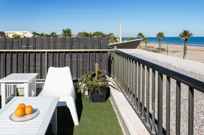 a balcony with a table and chairs and the beach at ApartUP Patacona Terrace Duplex I in Valencia