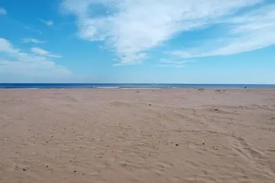 a sandy beach with a blue sky and the ocean at ApartUP Patacona Terrace Duplex I in Valencia