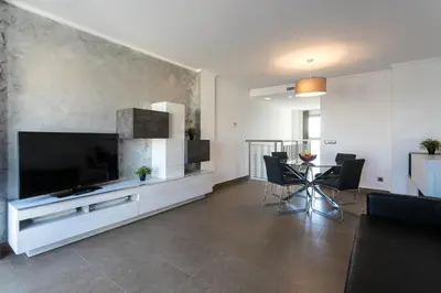 a living room with a large television and a table at ApartUP Patacona Terrace Duplex I in Valencia