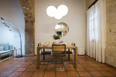a dining room with a table and chairs and a mirror at Apartamentos La Xerea in Valencia