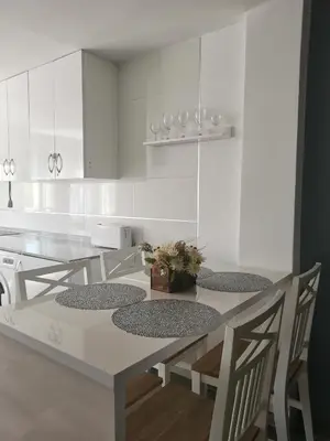 a kitchen with white cabinets and a table and chairs at Plaza Sainetero in Valencia