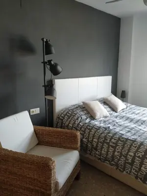 a bedroom with a bed and a chair at Apartamento Con Preciosas Vistas Al Mar,WIFI y piscina de temporada in Canet de Berenguer