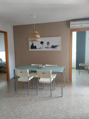 a dining room with a blue table and white chairs at Apartamento Con Preciosas Vistas Al Mar,WIFI y piscina de temporada in Canet de Berenguer