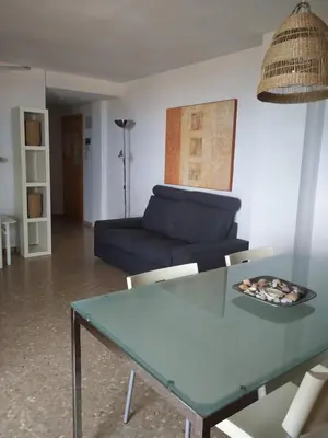 a living room with a blue table and a couch at Apartamento Con Preciosas Vistas Al Mar,WIFI y piscina de temporada in Canet de Berenguer