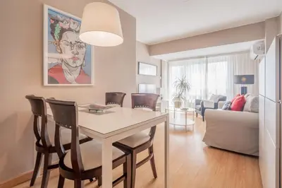 a dining room and living room with a table and chairs at 1ªLinea de playa Puerto de Sagunto in Puerto de Sagunto