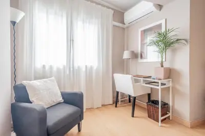 a living room with a chair and a desk at 1ªLinea de playa Puerto de Sagunto in Puerto de Sagunto