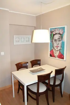 a dining room table with chairs and a painting at 1ªLinea de playa Puerto de Sagunto in Puerto de Sagunto