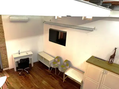 a room with chairs and a desk and a tv on a wall at Botanico Silence in Valencia