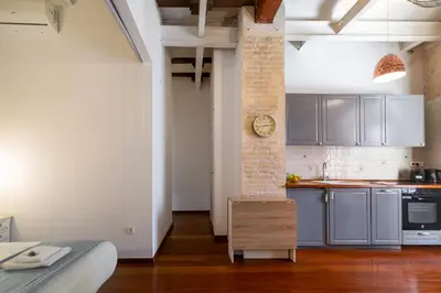 a kitchen with a clock on a brick pillar at Botanico Silence in Valencia