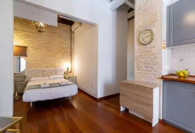 a room with a bed and a clock on a brick wall at Botanico Silence in Valencia