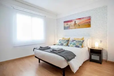 a white bedroom with a large bed and a window at Reus, Lovely Flat Close to Center in Valencia