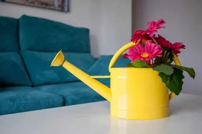 a yellow watering can with flowers in it on a table at Reus, Lovely Flat Close to Center in Valencia